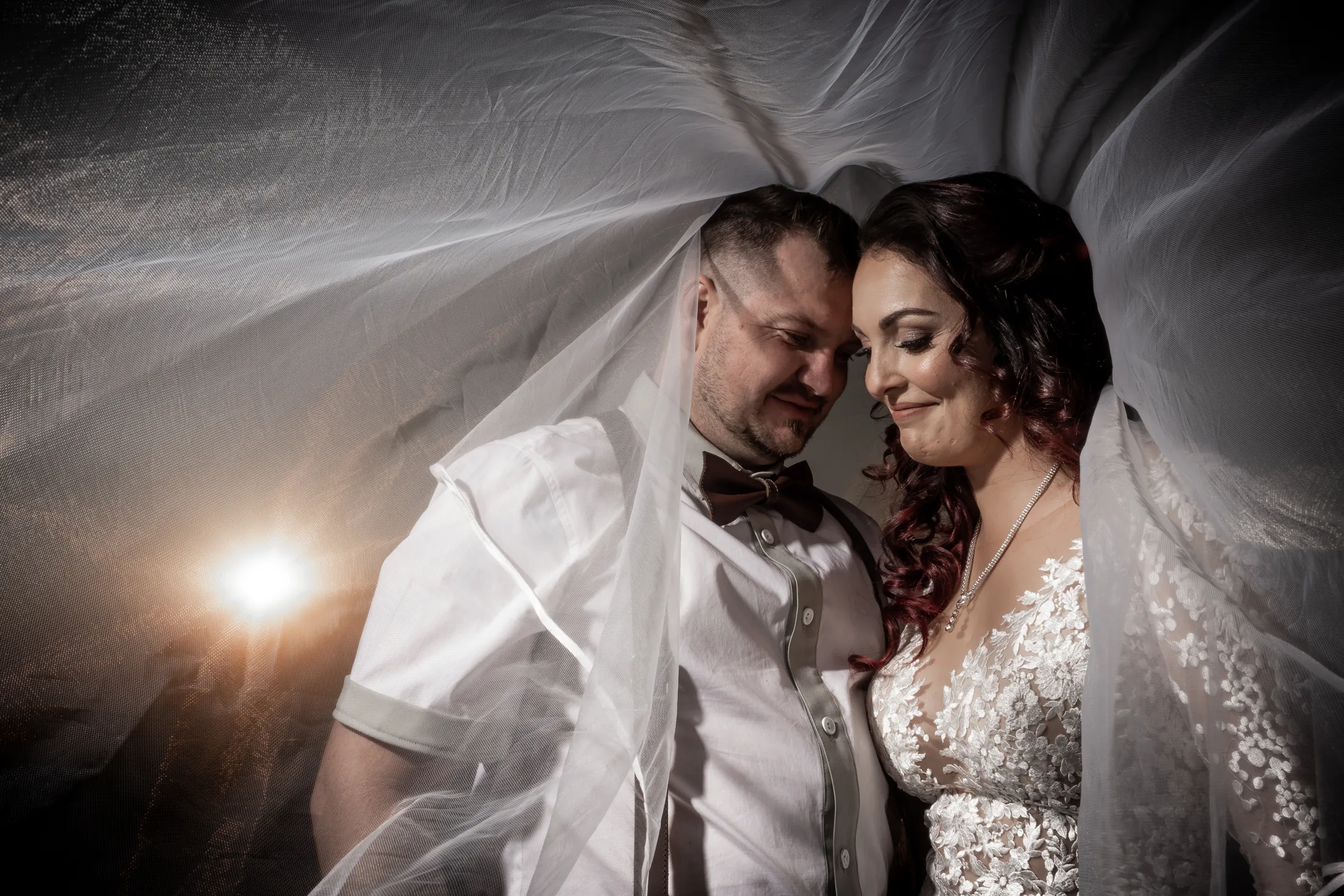 Armand and Melanie beneath her veil at dusk