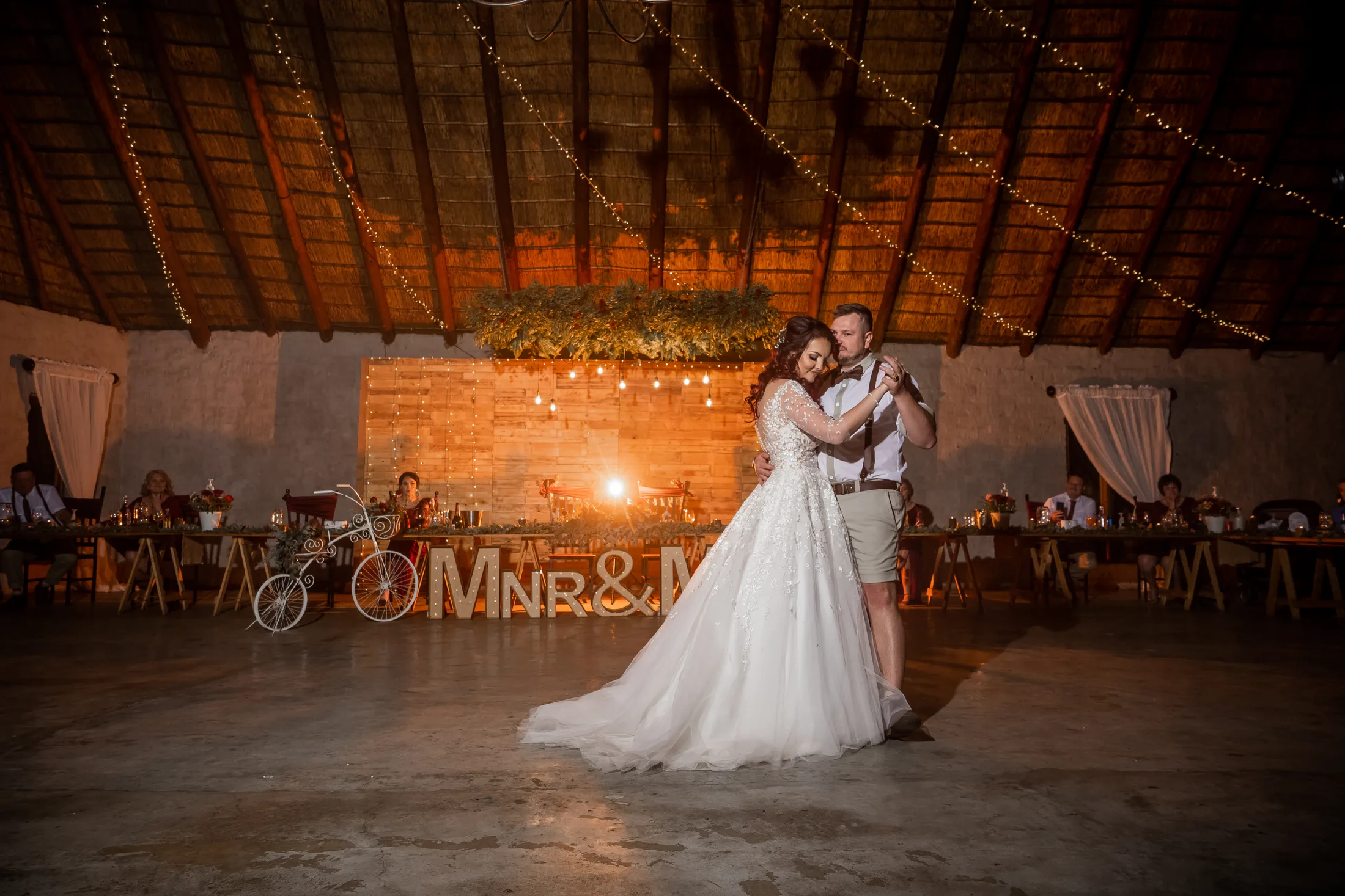 Armand and Melanie dancing with warm reception lights