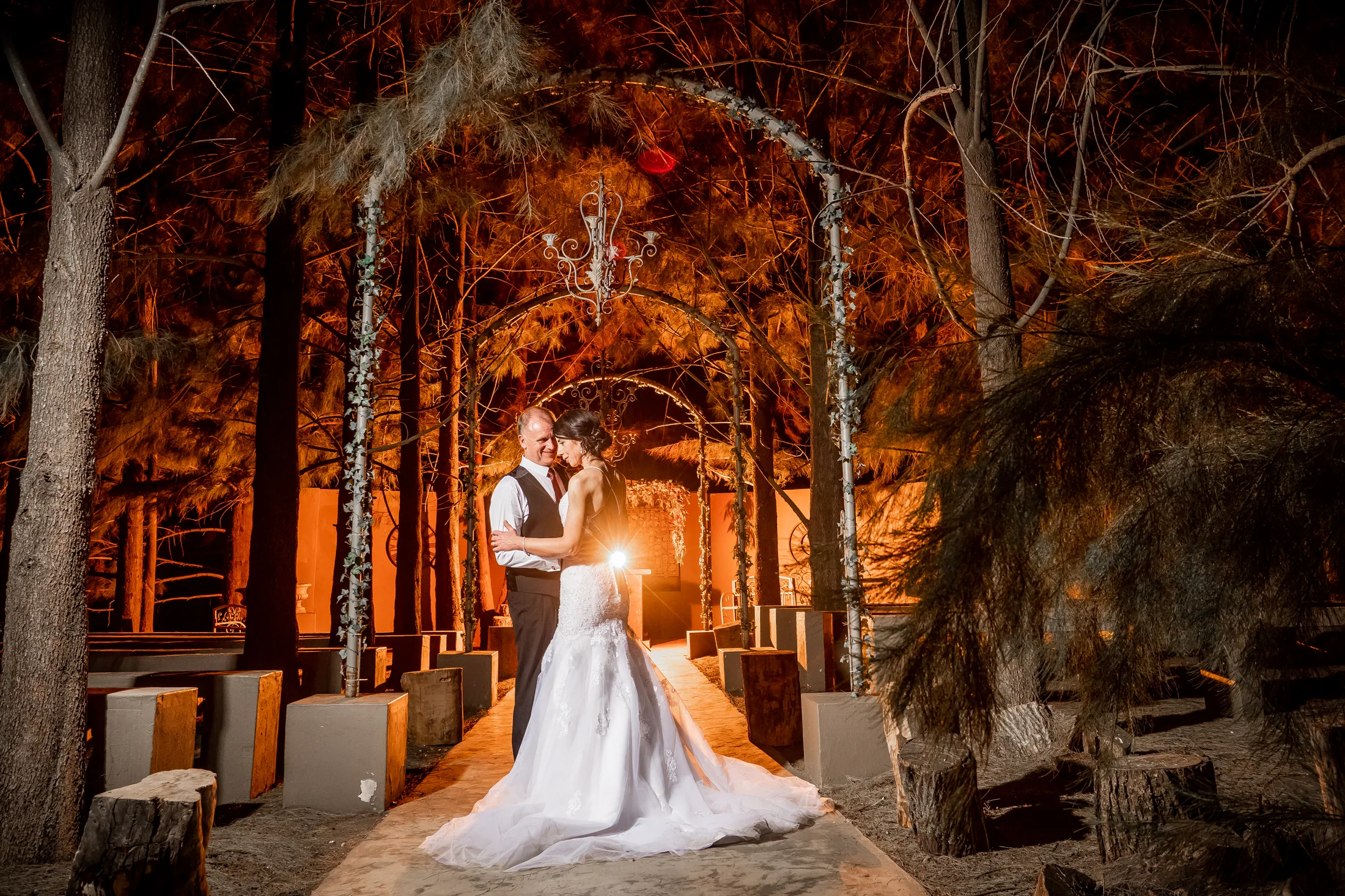 Billy and Karen in a warmly lit night portrait among the trees