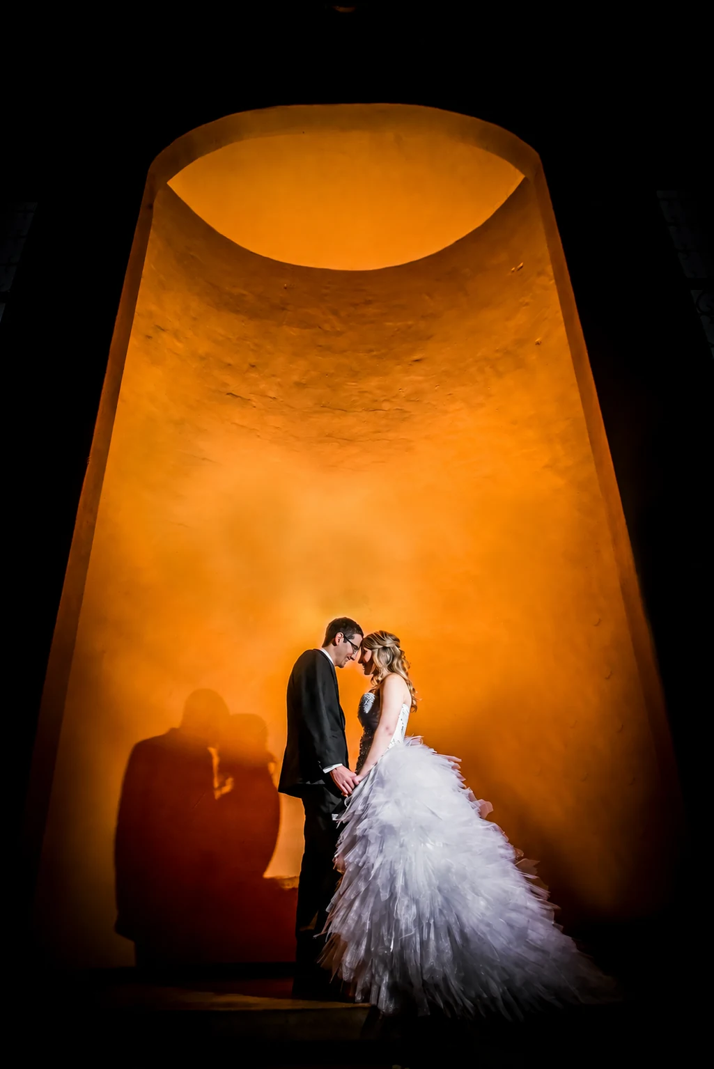 Silhouette of Ettienne and Dorme beneath a warmly lit arch