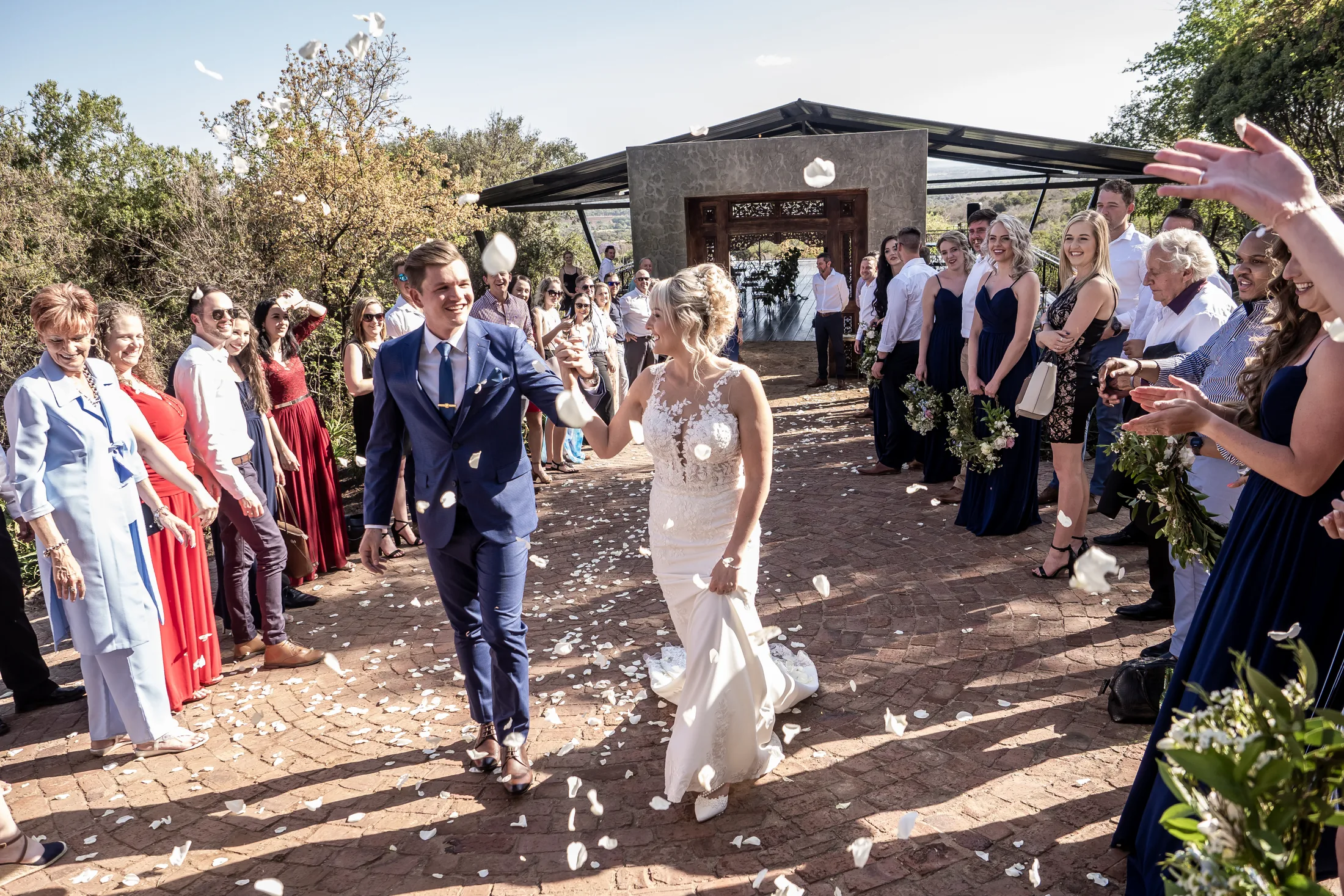 Xander and Leani walking through confetti after the ceremony