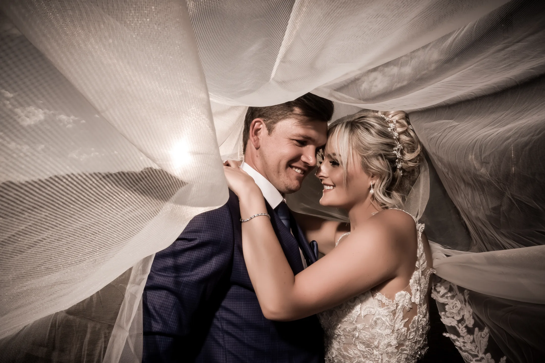 Close portrait of Xander and Leani beneath her veil